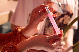 Person holding a 12ml travel spray with a blurred background