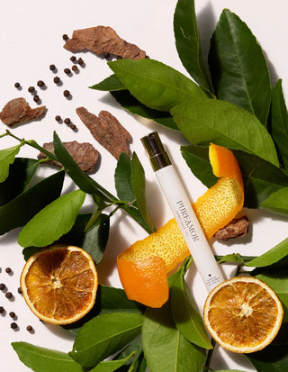 12ml travel spray Skincare product with oranges, leaves, and spices on a white background