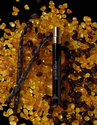 Vanilla pod, coffee beans, and amber stones with a 'PUREAMOR' product on a dark background 12ml