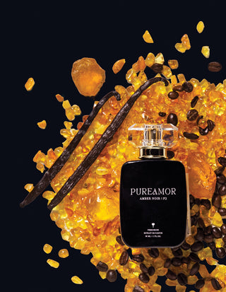 Perfume 30ml bottle labeled 'PUREAMOR' surrounded by amber, vanilla beans, and coffee beans on a black background.