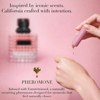 Hand holding a pink device with another bottle in the background on a pink background, featuring text about scents and pheromones.