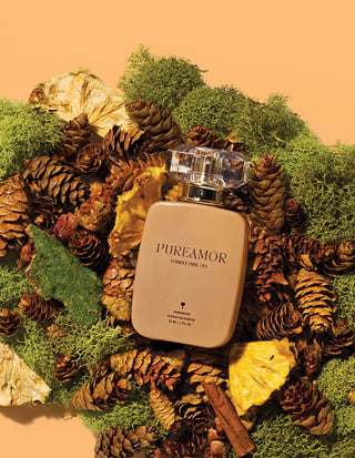 PUREAMOR 30ml perfume bottle surrounded by pinecones and leaves on a textured surface