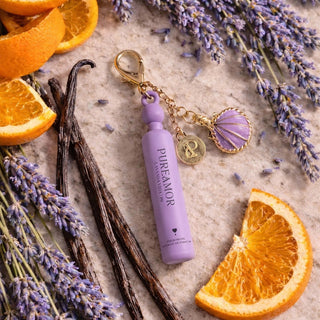 Purple 2ml keychain with gold accents on a surface with lavender, oranges, and vanilla beans.