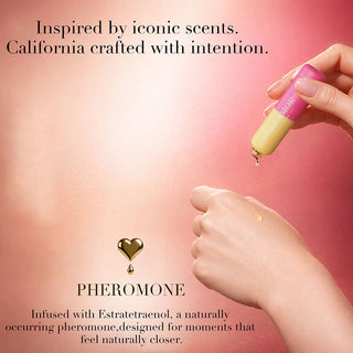 Hand holding a small bottle with a dropper, applying a drop to another hand against a pink background, with text about Pheromone products.