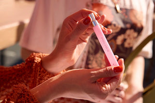 Person holding a 12ml travel spray with a blurred background