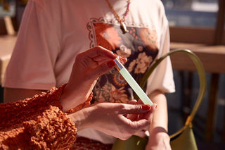 Person holding a Pure Amor Moonlight Mellow 12 ml travel spray with another person in the background
