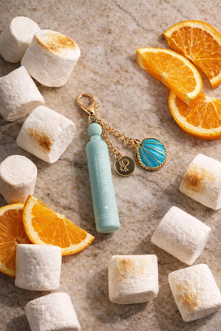 PureAmor Moonlight Mellow 2ml Keychain with blue and gold accents on a surface with marshmallows and orange slices.