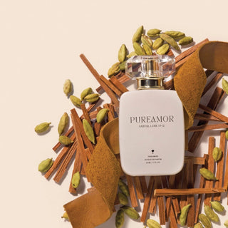 PureAmor Santal Luxe pheromone perfume 30 ml bottle styled with cardamom pods and wood pieces, emphasizing a warm, elegant scent.