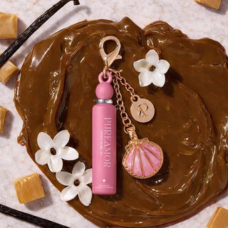 Compact PureAmor Sweet Rome 2ml  keychain, surrounded by caramel cubes and vanilla flowers.