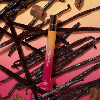 12ml travel spray Vanilla pod with a pink and yellow bottle labeled 'PURE AMOR' on a gradient background.