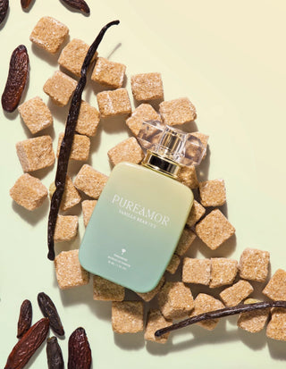 30ml Perfume bottle labeled 'PUREAMOR' surrounded by vanilla beans and sugar cubes on a light background