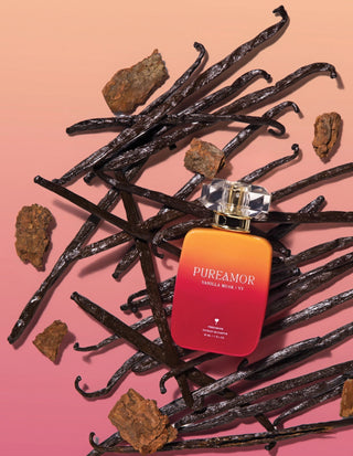 Pureamor Vanilla Musk perfume 30ml bottle surrounded by vanilla beans and wood bark on a pink gradient background.